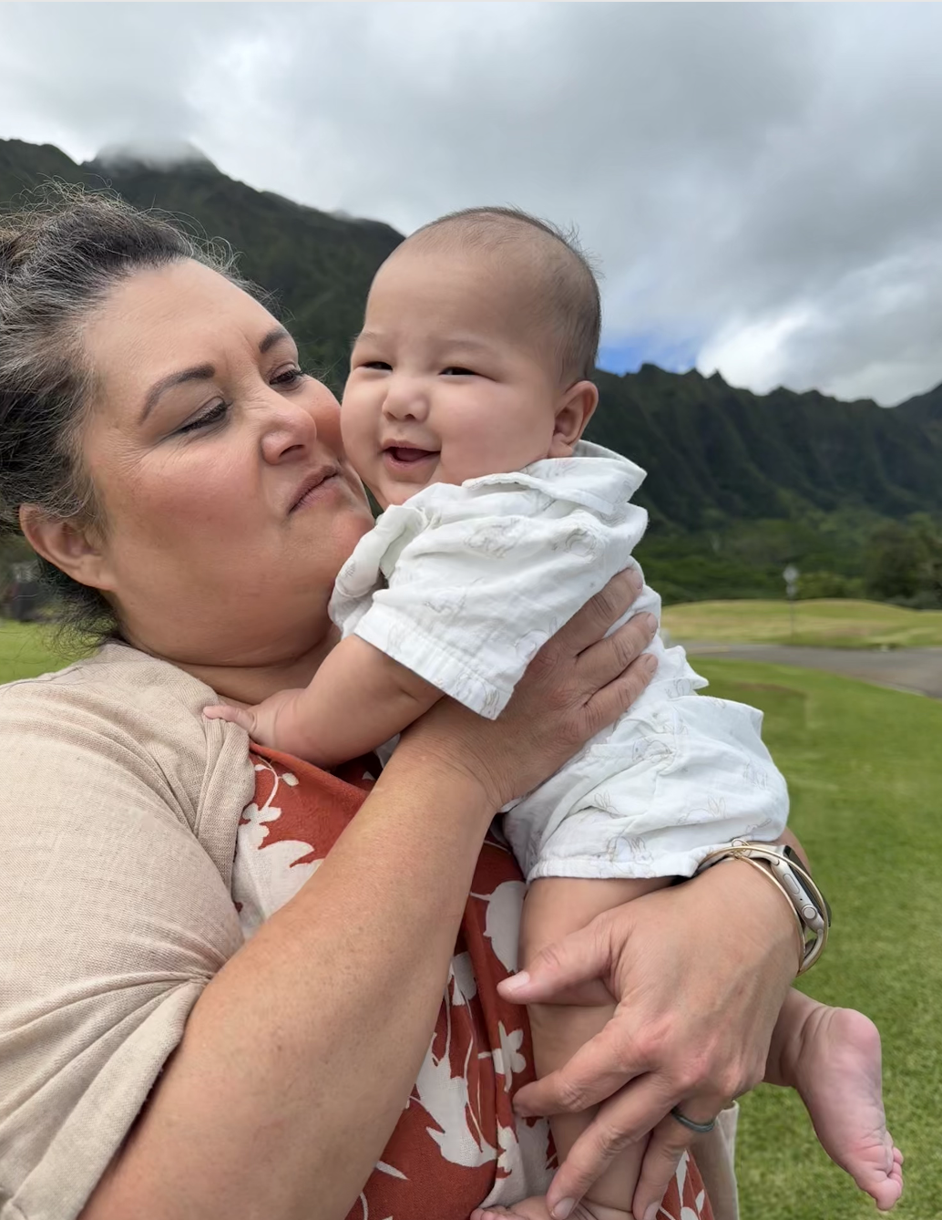 Mumu cuddling her grandbaby with the Ko'olau mountains behind them